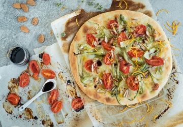 Pizza with tomato confit, puntarelle, almonds and orange