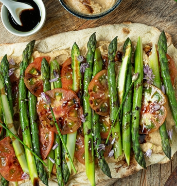 Crispy flat bread with asparagus, tomatoes and peanut hummus