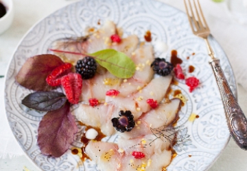 Crudo de pez limón con frutos rojos, hierbas y Vinagre Balsámico de Módena IGP